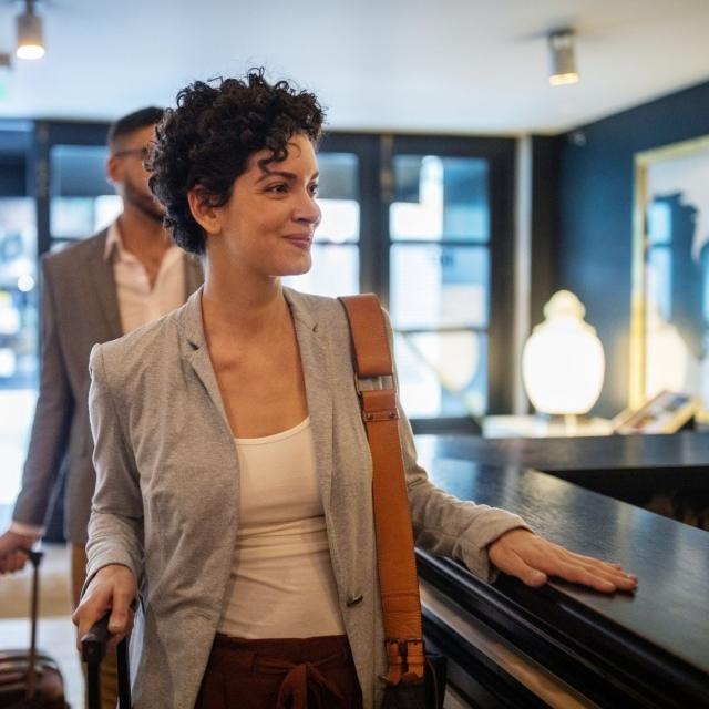 Woman traveler checking in at the front desk of hotel