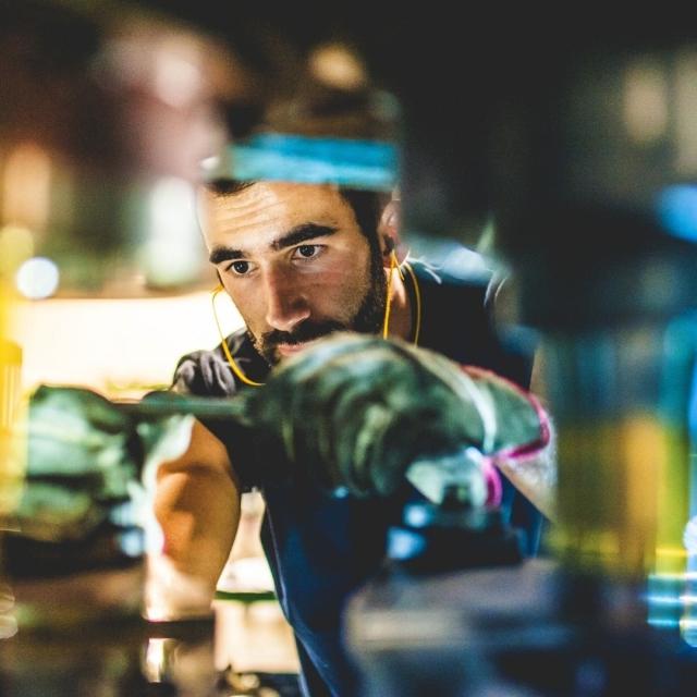 Bearded man wearing gloves repairing an item